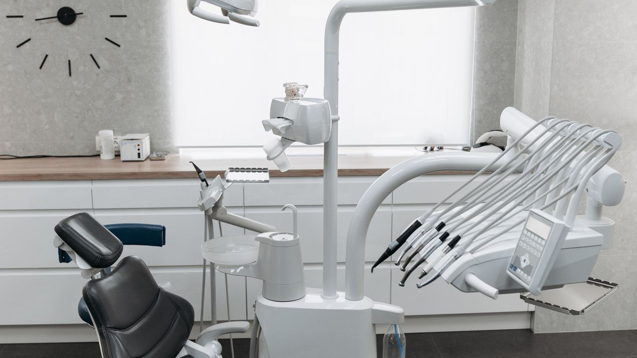 Interior de clínica odontológica premium com cadeira e equipamentos modernos