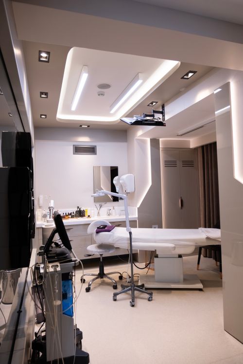 Sala de atendimento de clínica estética premium com equipamentos modernos e ambiente claro