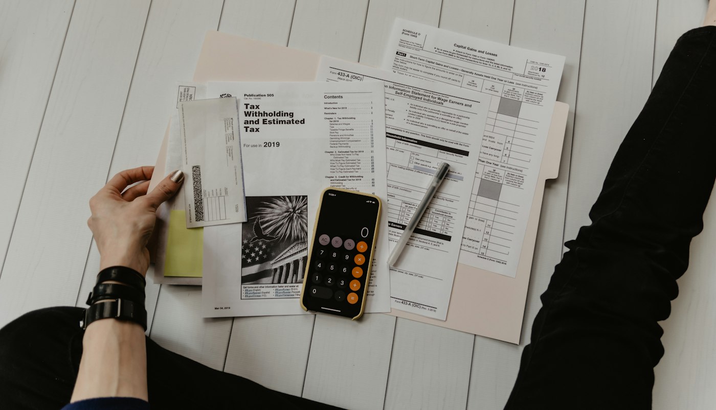 Documentos financeiros sobre mesa de trabalho, representando análise de carteira de clientes de contabilidade premium