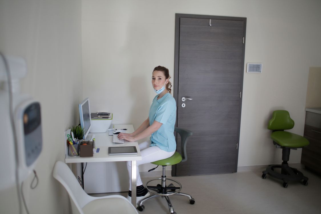 Médica analisando prontuários de pacientes em computador em consultório premium