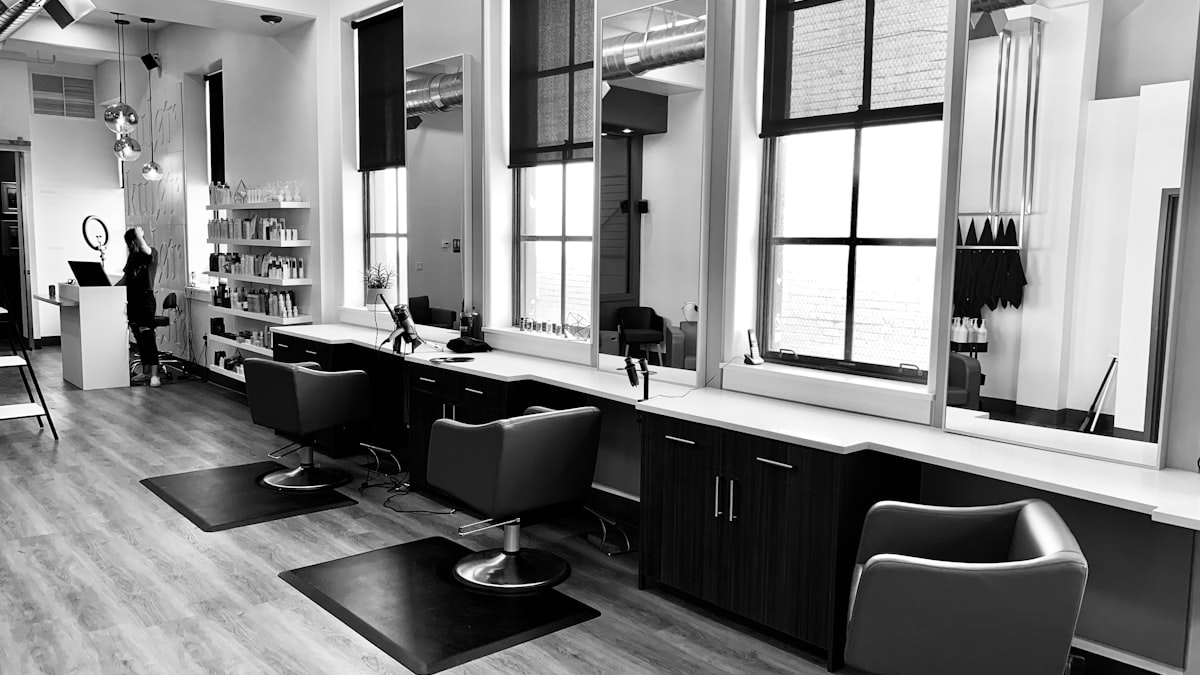 Interior de salão de beleza premium com cadeiras e espelhos em ambiente sofisticado