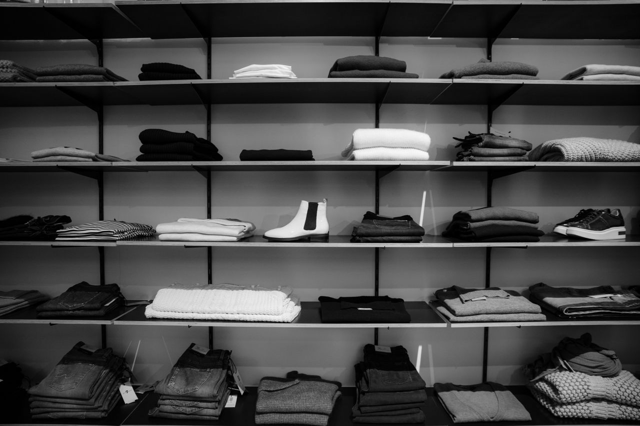 Interior de boutique premium com araras de roupa e ambiente elegante de varejo de alto padrão