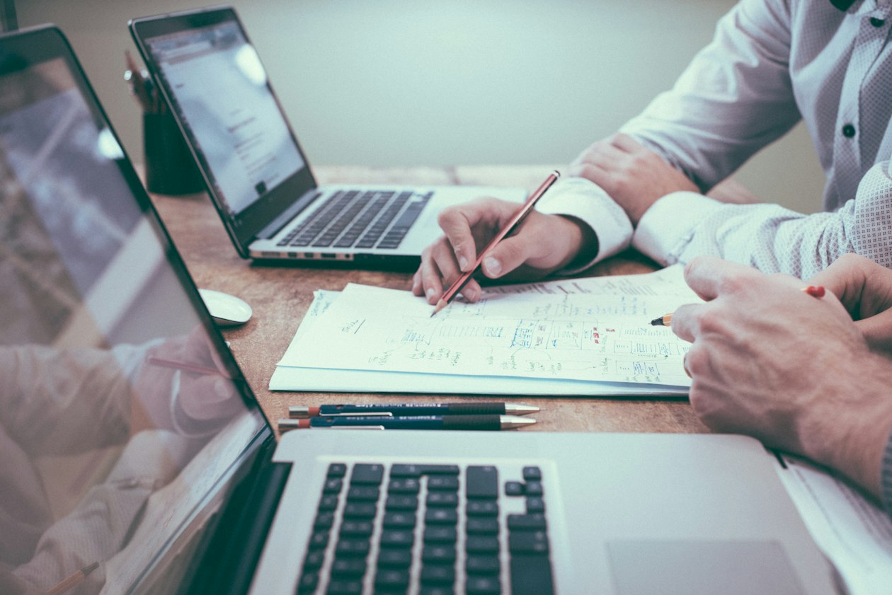 Duas pessoas em sessão de trabalho estratégico revisando documentos e planos juntas